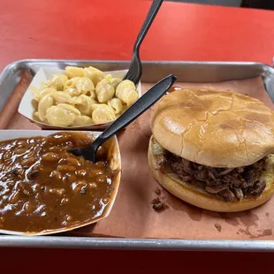 Chopped brisket sandwich, baked beans, and Mac and cheese.