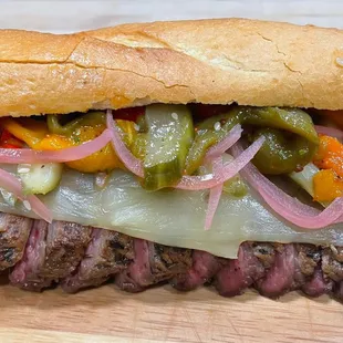 a steak sandwich with peppers and onions