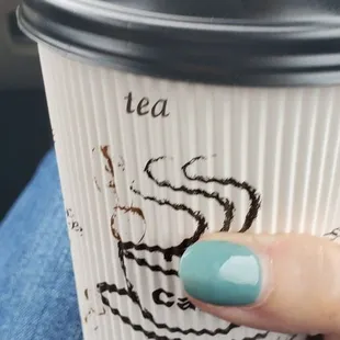 a hand holding a coffee cup