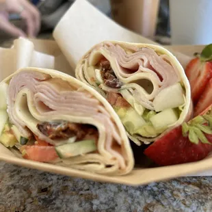 a plate of food with a sandwich and strawberries