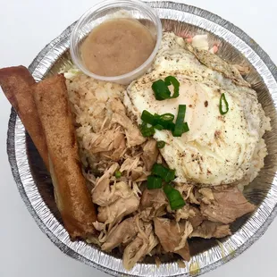 Rice Bowl combo with adobo pork, garlic rice, coleslaw, a soft-cooked egg, and two lumpia (egg rolls) with a sweet dipping sauce