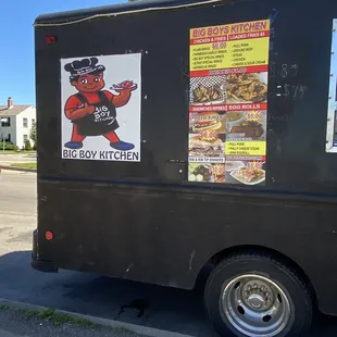 a black food truck parked on the side of the road