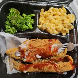 a tray of food with macaroni and cheese and broccoli