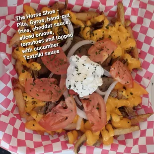 Our Horseshoe - Pita, Gyros, surrounded by cheese fries, topped with onions, tomatoes and cucumber Tzatziki sauce