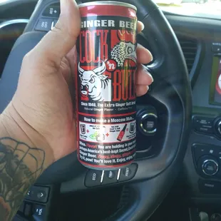 a hand holding a can of beer