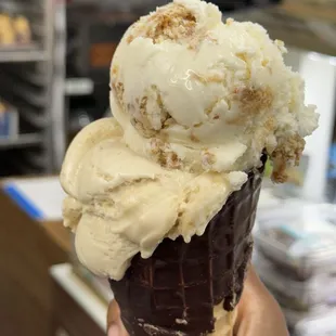 2 scoops on a chocolate cone. (Biscoff scoop, caramel pretzel scoop)