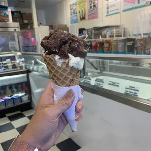 Waffle cone with one scoop of chocolate marshmallow and one scoop of cake batter ice cream