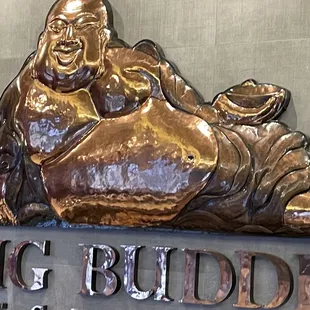 a bronze statue of a laughing buddha