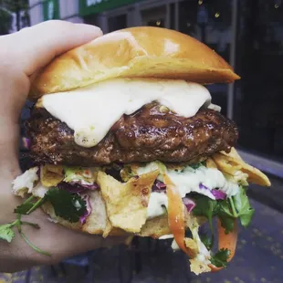 The Mexican Street Burger -- Taco-seasoned Angus Beef, Queso Fresco, Avocado Cream, Red Cabbage Lime-Cilantro Slaw, Crushed Fritos, Salsa