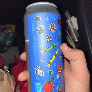 a person holding a can of soda