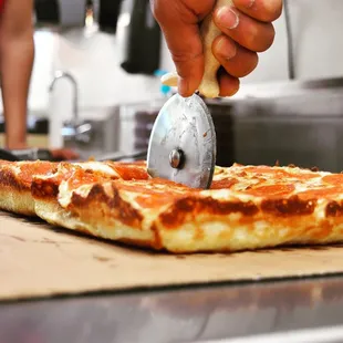 a person using a pizza cutter