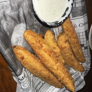 a bowl of ranched dip and some fried fish sticks