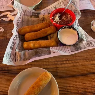 a plate of fried breadsticks and dipping sauce