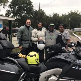 a group of people standing next to a motorcycle