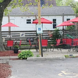a parking lot with red chairs and umbrellas