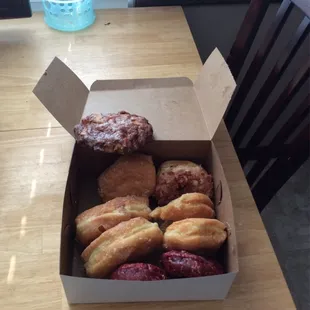 Counter clockwise from the top. Apple fritter,  2 chocolate fluffs, a raspberry Bismarck, 2 red velvet, original, &amp; maple bacon.