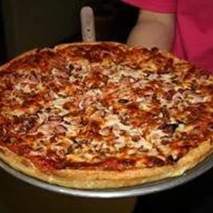 a person holding a large pizza