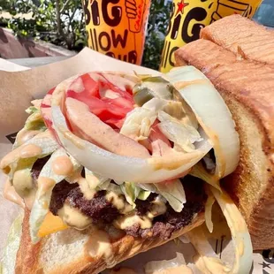 a sandwich with onions, lettuce, tomato, and cheese