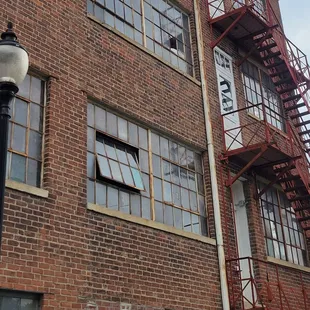 a tall brick building with fire escape stairs