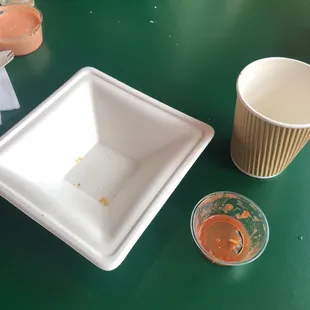 Small paper bowl of chips and tiny ramekin of salsa