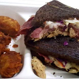 Carolina Reuben (Wagyu corned beef, pulled chicken, havarti cheese, Q vinaigrette slaw, Q Gold sauce, toasted marble rye) and Tater Tots.