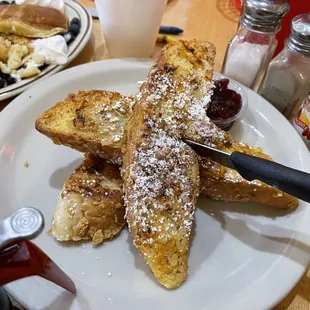 a plate of french toast with powdered sugar on top