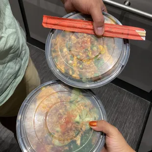 Two poke bowls both with two scoops of protein and three toppings each