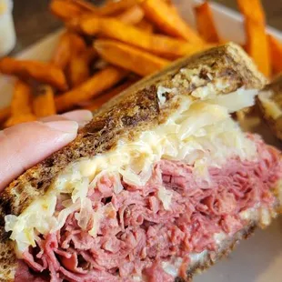 a hand holding a sandwich