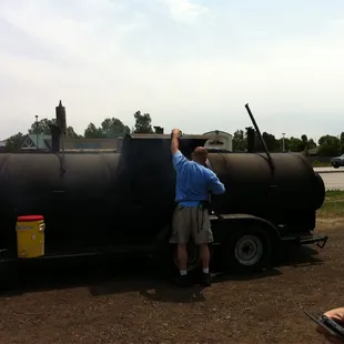 a man standing in front of a large bbq
