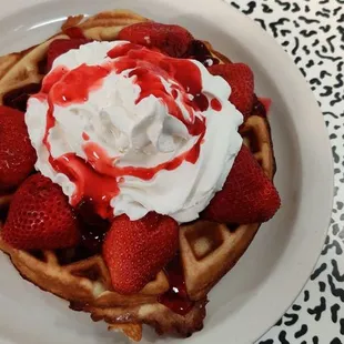 a waffle with whipped cream and strawberries