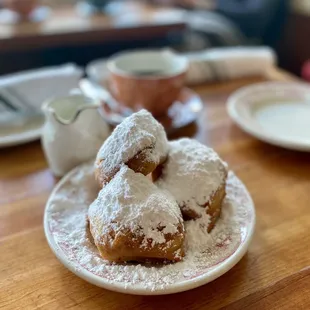 a plate of powdered sugar pastries