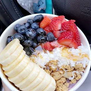 a person holding a bowl of fruit