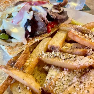 Philly cheesecake with beef + added queso  Steak fries with garlic parm seasoning
