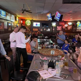 a large group of people eating pizza