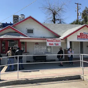a group of people standing outside of a restaurant