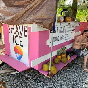 a man and a woman sitting in front of an ice cream stand
