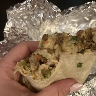 a hand holding a burrito