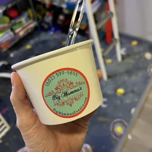 a person holding a cup of ice cream