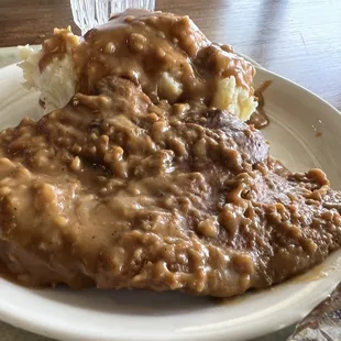 Smothered porkchop and mashed potatoes closeup.