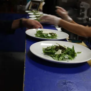 two plates of salad on a blue table