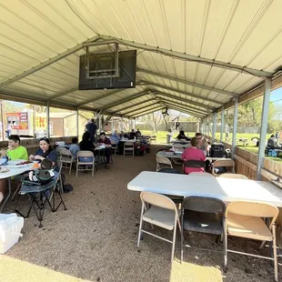 people sitting at tables under a tent