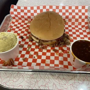 Pulled pork sandwich platter with 2 sides potato salad (yellow) and baked beans
