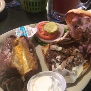 Swiss cheese mushroom burger with baked potato on the side