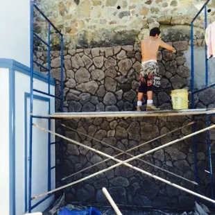 Moss rock being installed over CMU