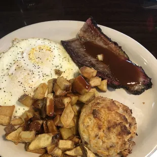 Traditional breakfast with brisket and a biscuit.