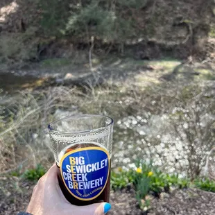 a person holding a glass of beer