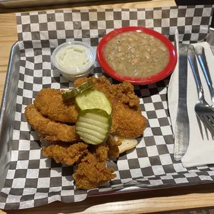 Chicken tenders with ranch dipping sauce and beans as a side