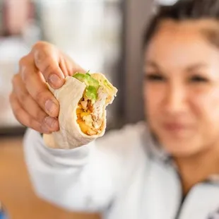 a woman holding a burrito