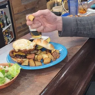 a man putting mustard on a burger