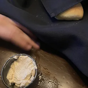 a person's hand reaching for a piece of bread